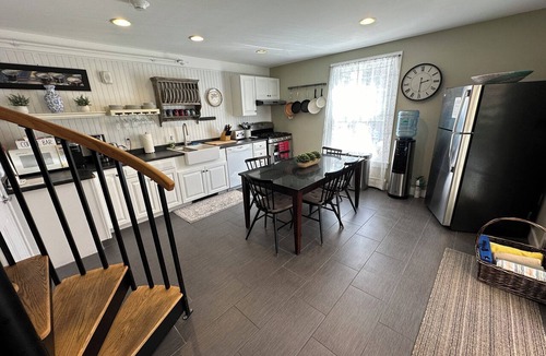 Newport Hotel | Dive into downtown Newport RI in this private, large, unique townhouse-style 2BR apartment at 205 Spring St! King and Full beds + pull-out sofa full kitchen, 2 baths, outdoor patio, AC, TVs, Wifi. Just steps to Thames Street, shops and wharfs