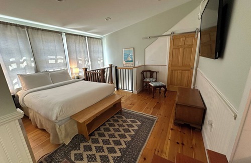 Newport Hotel | Dive into downtown Newport RI in this private, large, unique townhouse-style 2BR apartment at 205 Spring St! King and Full beds + pull-out sofa full kitchen, 2 baths, outdoor patio, AC, TVs, Wifi. Just steps to Thames Street, shops and wharfs